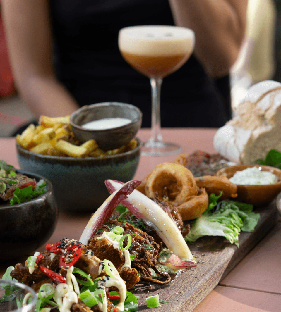 Table with serving board, fries and a cocktail